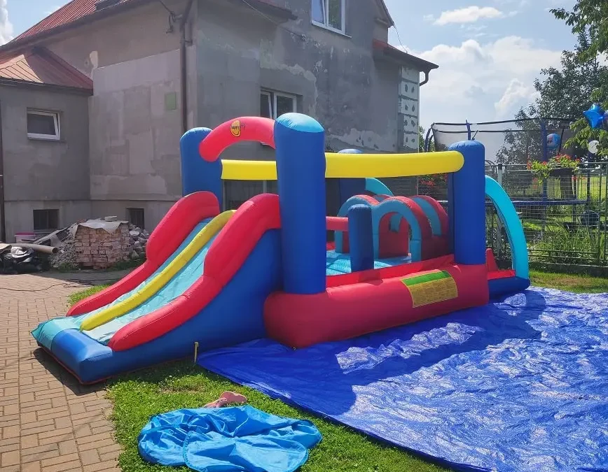 rodinný dům a skákací hrad na zahradě pro děti
