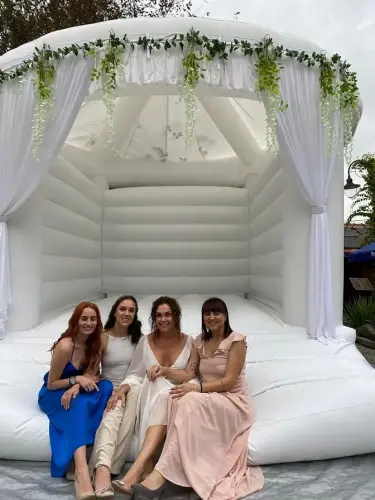družičky a nevěsta sedí na svatebním nafukovacím hradu